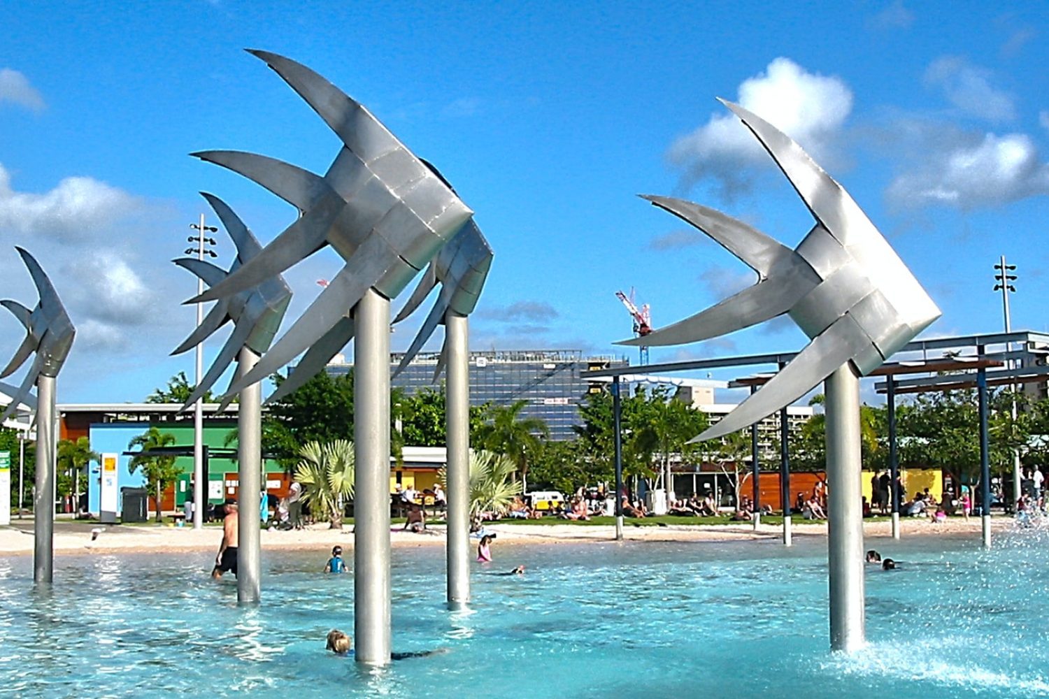 people walking on park with gray concrete fountain during daytime